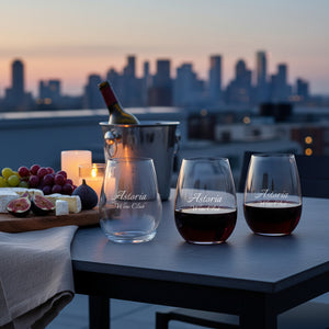 Wine glasses with 'Astoria Wine Club' branding on a table with a city skyline in the background.