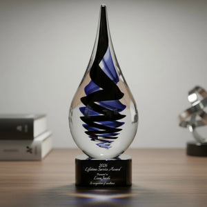 Glass award with black and blue design on a wooden surface