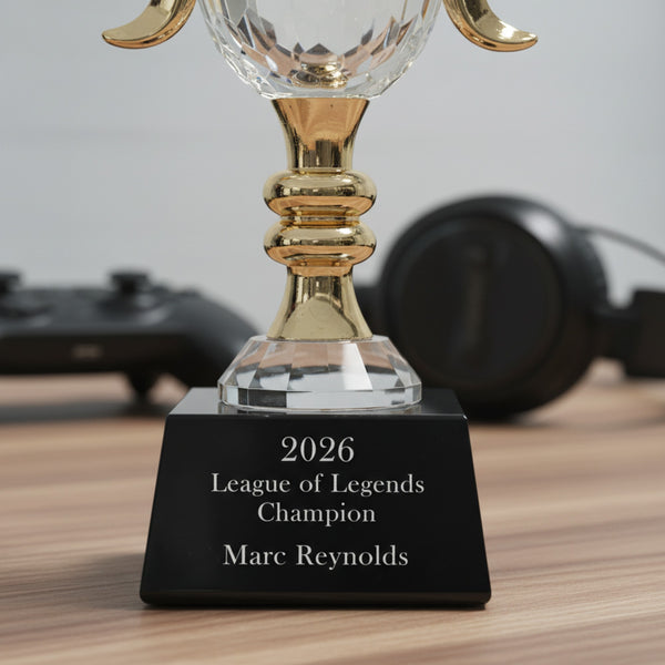 Trophy with '2026 League of Legends Champion Marc Reynolds' on a wooden surface.