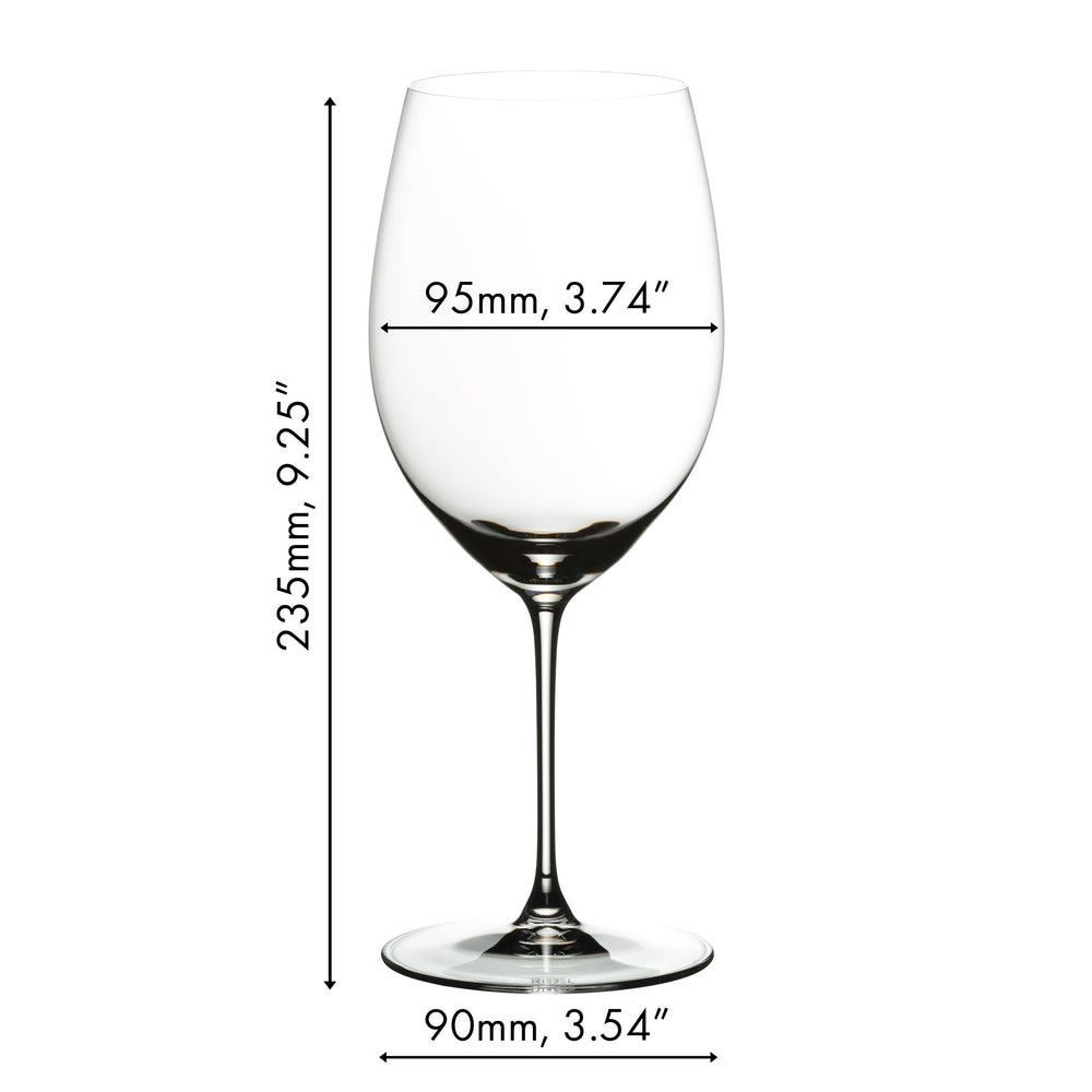 Two wine glasses with 'Mr. & Mrs. Johanson' engraving on a table with appetizers and a candle.